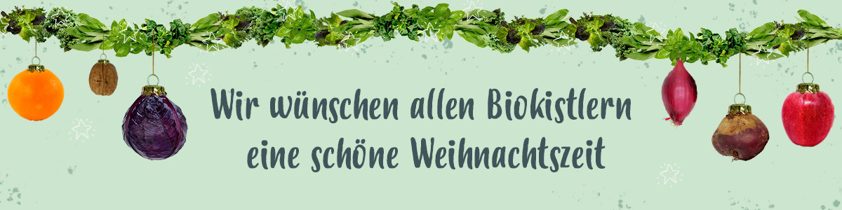 Das Bild zeigt eine festliche Girlande aus Gemüse, begleitet von dem Text "Wir wünschen allen Biokistlern eine schöne Weihnachtszeit". Die Darstellung kombiniert weihnachtliche Dekoration mit dem Thema Biolebensmittel.